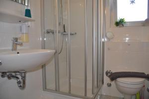 Un baño con ducha, lavabo e inodoro. en Haus Nordstrand Vereinsalle 21WHG 2 6, en Büsum 23 fotos más
