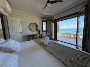 Un dormitorio con una cama con vista al mar. en Exceptional beachfront villa Blue Pearl, en Pefkohori