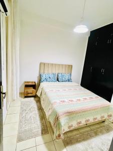 une chambre avec un grand lit avec des oreillers bleus dans l'établissement Cozy apartment, in secure residence, à Agadir