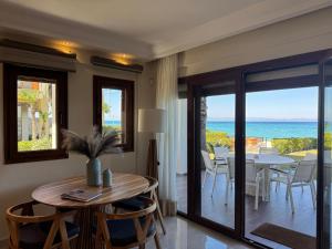 Un comedor con mesa y vista al mar. en Exceptional beachfront villa Blue Pearl, en Pefkohori