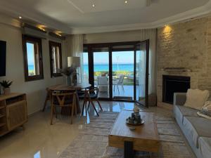 una sala de estar con un sofá y una mesa en Exceptional beachfront villa Blue Pearl, en Pefkohori