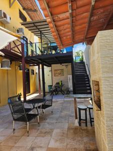 a patio with a table and chairs and a staircase at Pousada Coco Verde Natal in Natal