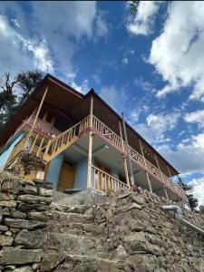 a house sitting on top of a stone wall at Mountain retreat in Jibhi