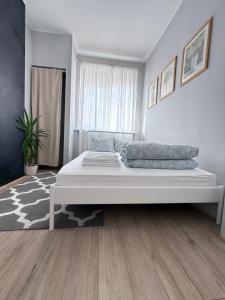 a white bedroom with a large bed in it at Sunhaus in Gdynia