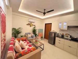 a living room with a couch and a kitchen at Couple Canvas- Luxurious 1-BHK Peaceful Apartment in Siroli