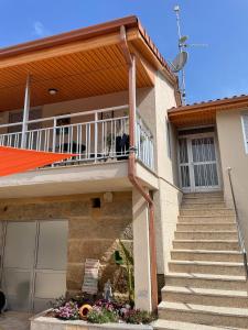 a house with a balcony and stairs at A Casa do Abuelo in Ourense +19 photos