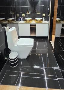 a bathroom with a toilet and a black tiled floor at Modern private home with Pool, Patio and Sundeck in San Juan