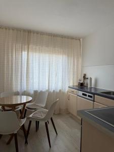 a kitchen with a table and white chairs and a table and a table at Casa Emilio in Haßloch