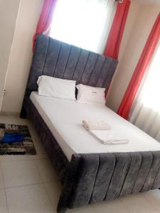 a large bed in a room with a window at Delta shop house in Mombasa