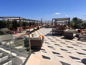 a group of people sitting in lounge chairs on a roof at Corner 1 Bed Apart in Mercury Suites with Rooftop Pool Seasonal in St. Julianʼs +12 photos