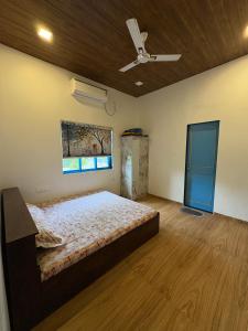 a bedroom with a bed and a ceiling fan at Aweka Villa - 3 BHK Riverside - Karjat in Dhamni