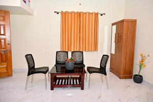 a room with a table and chairs and a curtain at Siri Kuteera Homestay in Chikmagalūr