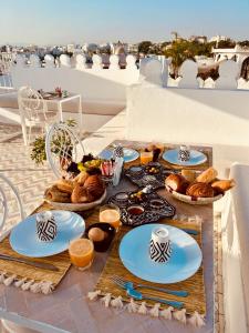 una mesa con platos de comida y cestas de pan en Riad Dar Elif, en Tánger