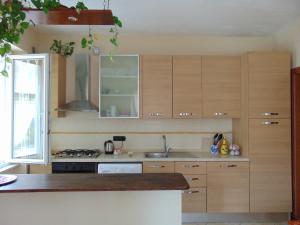 a kitchen with wooden cabinets and a sink at Appartamenti Ca'Melia in Sarzana
