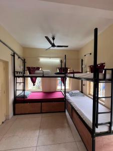 a room with three bunk beds and a ceiling fan at ROAMERS INN Backpackers Hostel in Kolkata