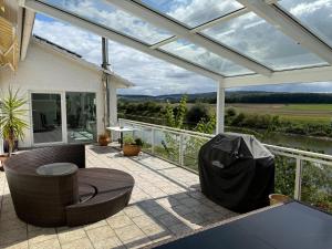 a conservatory with a table and chairs on a patio at Haus an der Weser Ferienwohnung in Brevörde