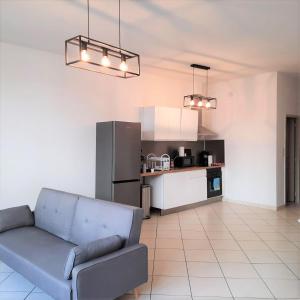 un salon avec un canapé et une cuisine dans l'établissement Appartement tout équipé 4 à 6 couchages au cœur de Beziers, à Béziers
