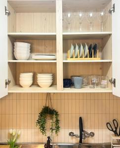 a kitchen cabinet filled with plates and bowls at Merryin Stay #길동역5분 #무료짐보관 #KSPO #롯데월드 #아산병원 in Seoul +21 photos