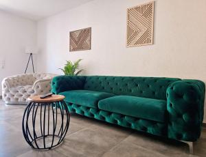 a green couch in a living room with a table at Eibauer Apartments in Sinsheim