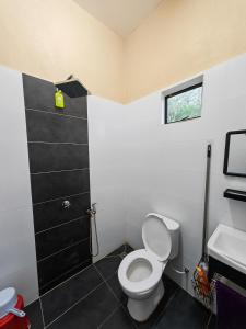 a bathroom with a toilet and a sink at GreenAcres Cottage in Pasir Puteh +14 photos
