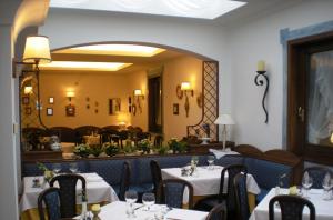 a restaurant with white tables and chairs and a mirror at Bike-Hotel Abete in San Giovanni Rotondo