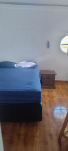 a bedroom with a blue bed and a wooden floor at Guest House in Petrópolis in Petrópolis