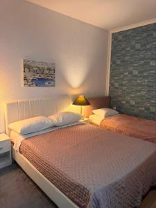 a bedroom with two beds and a lamp in it at Apartments Kruno in Međugorje