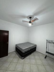 a bedroom with a bed and a ceiling fan at Casa de Frente com Maria in Aparecida