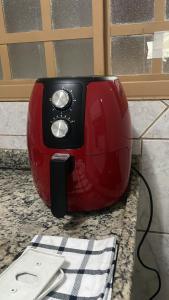 a red toaster sitting on top of a counter at Casa de Frente com Maria in Aparecida