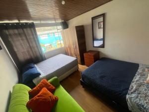a bedroom with a bed and a couch and a window at Best Habitaciones junto a Clinica Santa Fe in Bogotá