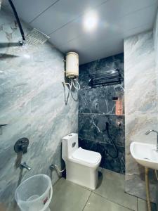 un baño con inodoro y lavabo en Hotel Shreenath Kathiyawadi And Pure Veg Kathiyawadi Restaurant Udaipur, en Udaipur