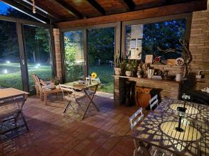 a screened in patio with a table and a fireplace at BnB Bagno di Bosco in Gubbio