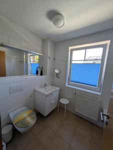a bathroom with a toilet and a sink and a window at Ferienwohnung in Boltenhagen in Boltenhagen