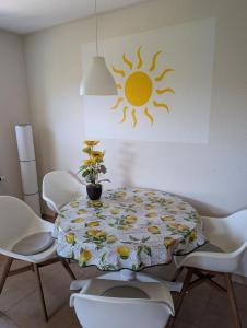 a dining room table with a sun on the wall at Ferienwohnung in Boltenhagen in Boltenhagen +5 photos