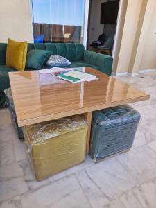 a wooden coffee table in a living room with a couch at Bel appartement pour location in O Ben Slimane