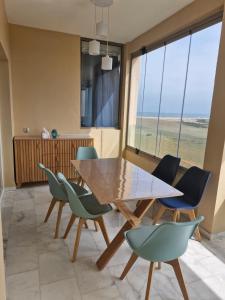 a dining room with a wooden table and chairs at Bel appartement pour location in O Ben Slimane