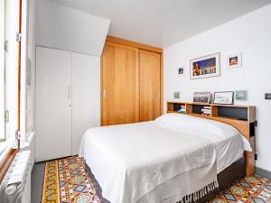a bedroom with a white bed and a wooden cabinet at Appartement à 100m de la plage dans le quartier historique in Collioure