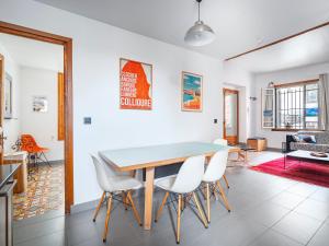 a dining room with a table and white chairs at Appartement à 100m de la plage dans le quartier historique in Collioure
