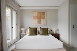 a bedroom with a large white bed and a window at Maison MUSA at Ca' Bela in Sala Comacina +7 photos