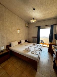 a bedroom with a large bed and a large window at Sariza Spring Hotel in Andros +75 photos