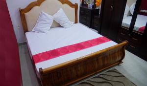 - une chambre avec un lit doté d'un cadre en bois et d'un miroir dans l'établissement Dazicor Retreats - Luxury Villa in Kottarakara, 