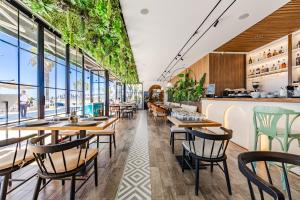 a restaurant with tables and chairs and windows at Hotel Villa Verona in Durrës