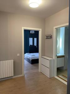 Cozy Apartment For Daily Rent في تبليسي: غرفة بسرير ومرآة