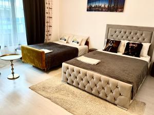 a hotel room with two beds and a table at QUOVADIS Apart in Otopeni