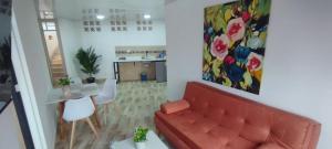 a living room with a red couch and a table at Hospedarte Cali Sur in Cali