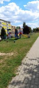 a park with playground equipment in the grass at Apartament Biedronka in Nowa Ruda