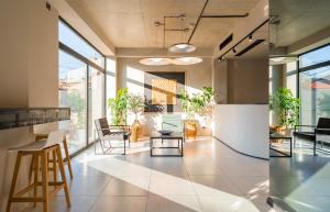 an office lobby with chairs and tables and windows at Doors Boutique Hotel in Tbilisi City
