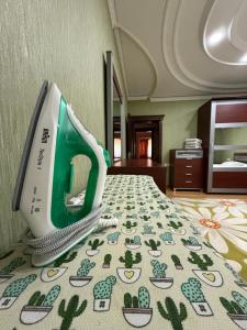 a green and white appliance sitting on top of a bed at CHEKHOV APARTMENT in Tashkent