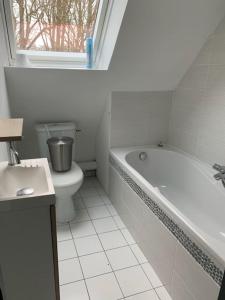 a bathroom with a tub and a toilet and a sink at Parc an Porz in Lannion