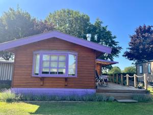 a small house with a porch and a deck at Chalet Lavendel in Schimmert